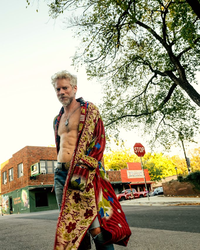 Walking a tree-lined street in a floral robe, golden hour